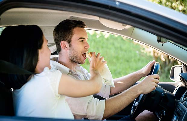 Γυναίκα τρέφει άνδρα ενώ οδηγεί με υγιεινά σνακ